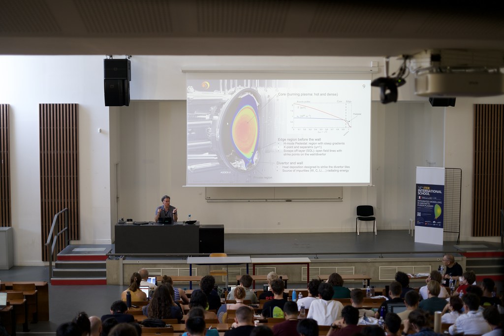 Lecture session at the 14th ITER International School in Aix-en-Provence, with a slide on burning-plasma core physics projected on screen.